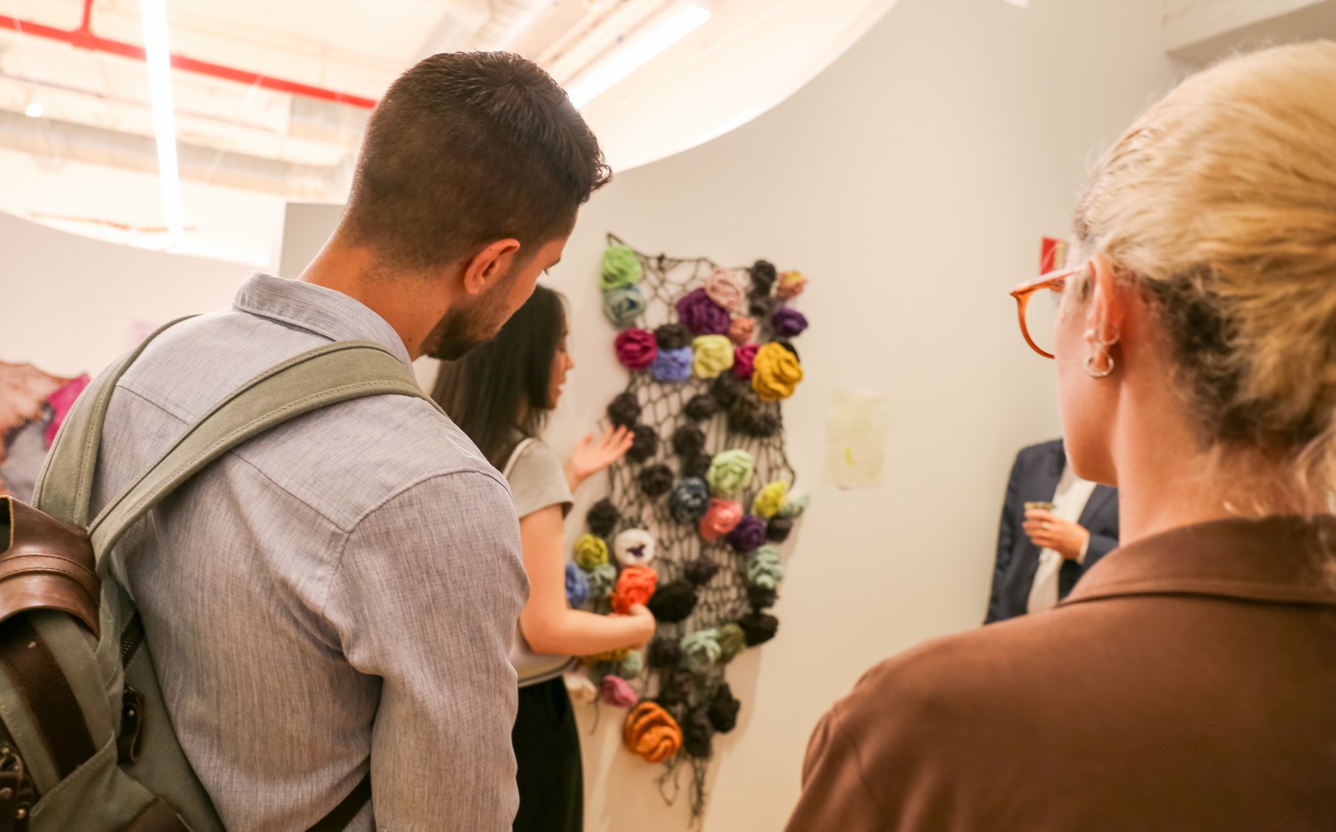 Guests admire a crocheted textile piece visualizing IOM data on Myanmar migrants entering Thailand through Tak, Ranong, and Kanchanaburi provinces. Photo: Parsons MFA Textiles 2025/Jason Philip Greenberg